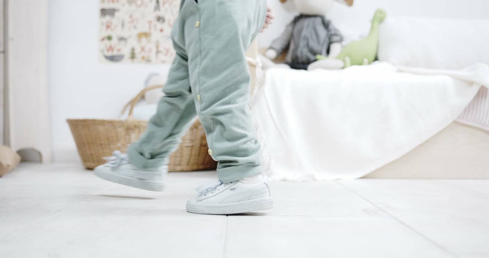 A child walking across a bright bedroom floor